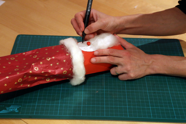 Mit Filzstift kannst du deinem Nikolaus nun Augen aufmalen. Forme aus einem kleinen Stückchen rotem Papier eine kleine Kugel. Das ist die Nase.