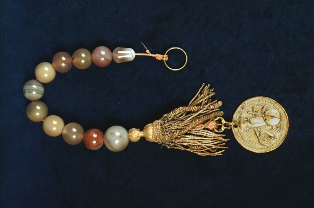 Rosenkranz, Zehner aus Achat, um 1600/1700, Länge 43 cm. Ein gezierter Herrenring oben und eine Medaille aus dem 16. Jh., mit Boullionquaste unten schließen die offene Kette ab.