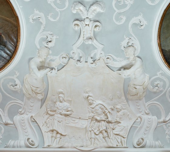 Stuckmedaillon "Der Mord an Kleitos" von Alberto Camesina im Konferenzzimmer, 1709-1711. Die drei Straußenfedern über dem Medaillon symbolisieren das Wappen von Fürsterzbischof Harrach © DQS/Kirchberger