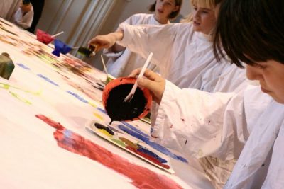 Kinder beim Farben ausschütten und malen
